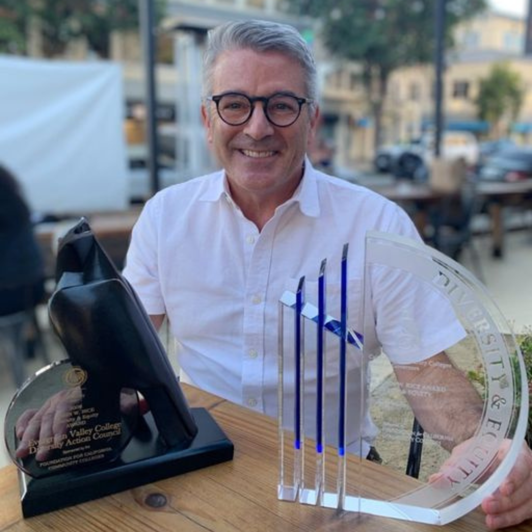 Person sitting at a table with two awards