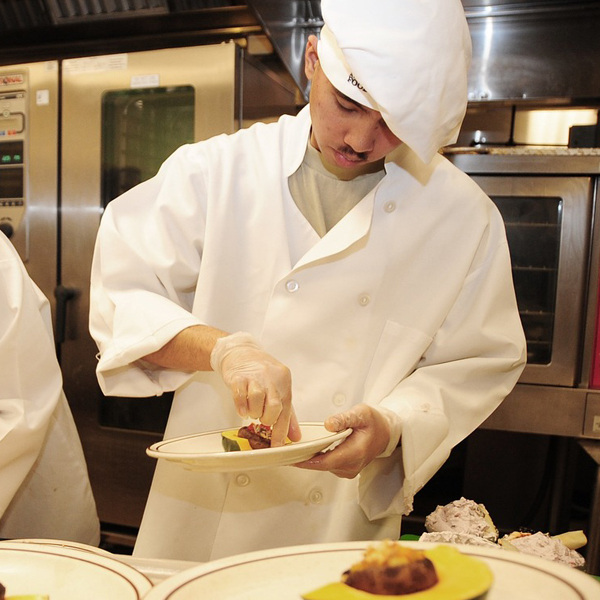 Chef plating food in a kitchen